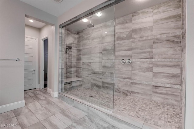 full bathroom featuring recessed lighting, baseboards, and tiled shower