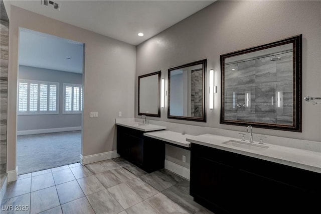bathroom with two vanities, visible vents, a sink, and a tile shower