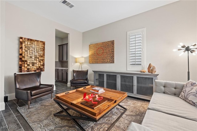 living room featuring baseboards, wood finished floors, and visible vents