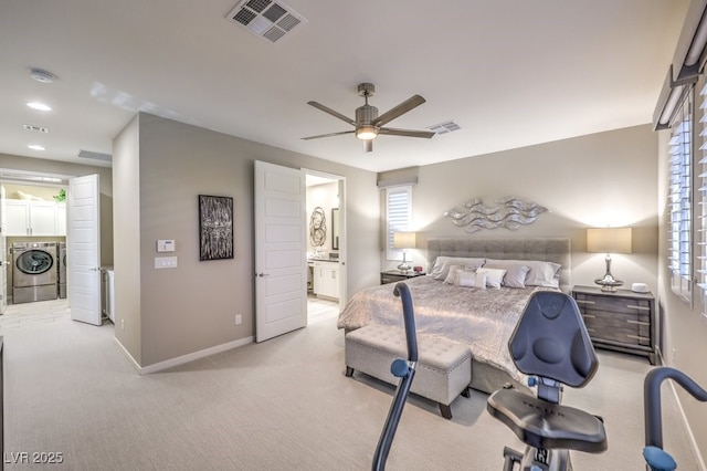 carpeted bedroom with ensuite bath, ceiling fan, and separate washer and dryer