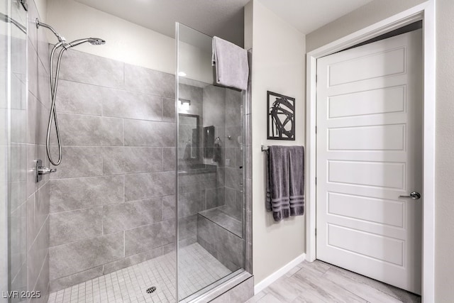 bathroom with hardwood / wood-style flooring and tiled shower