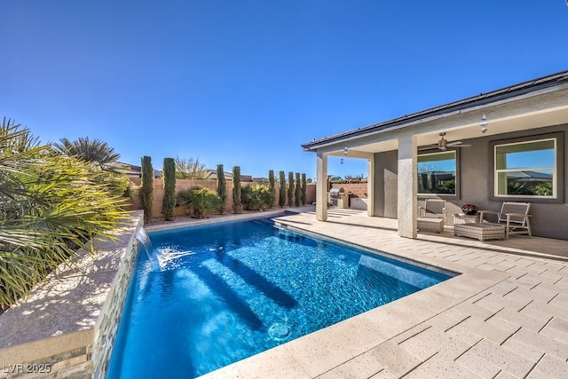 view of swimming pool with pool water feature, ceiling fan, and a patio