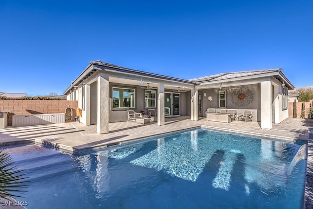 rear view of house with pool water feature, a fenced in pool, ceiling fan, and a patio area