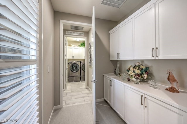 bar with white cabinets and separate washer and dryer