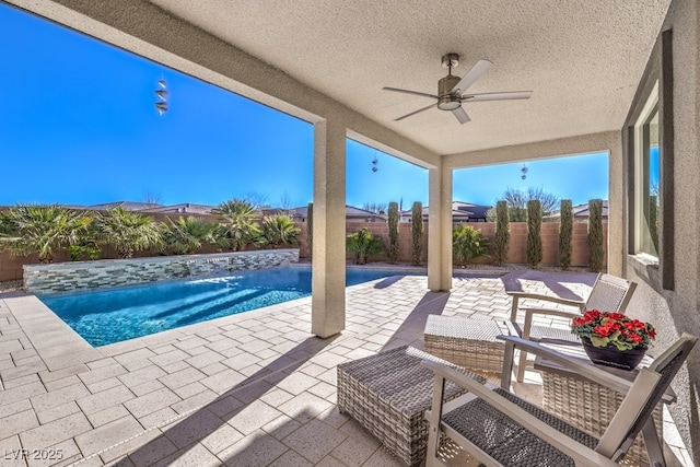 view of swimming pool with ceiling fan and a patio area