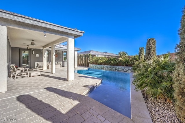 view of pool with an outdoor hangout area, pool water feature, ceiling fan, and a patio area