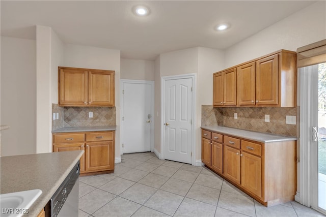 kitchen with backsplash, stainless steel dishwasher, sink, and light tile patterned floors