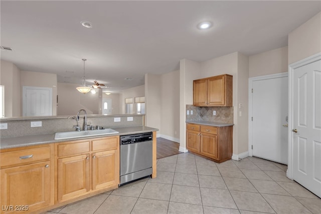 kitchen with tasteful backsplash, dishwasher, sink, hanging light fixtures, and light tile patterned floors