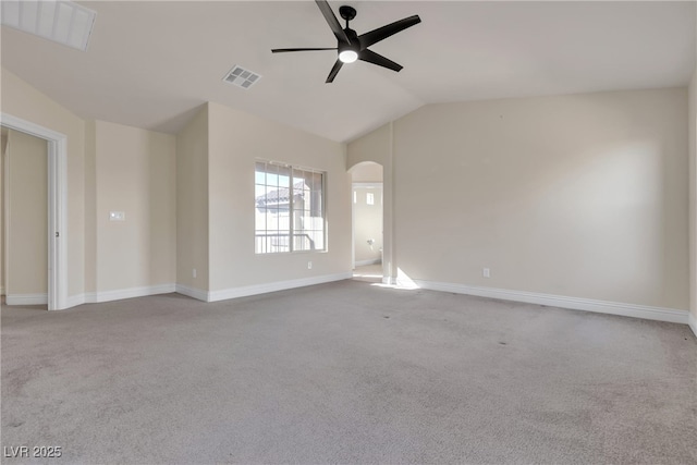 spare room featuring light carpet, vaulted ceiling, and ceiling fan