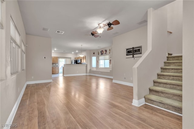 unfurnished living room featuring ceiling fan and light hardwood / wood-style floors