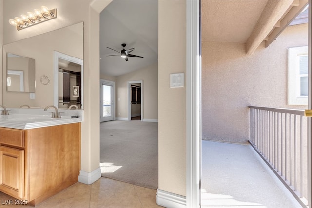 bathroom with tile patterned flooring, vanity, vaulted ceiling, and ceiling fan