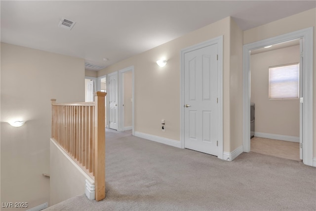 hall with light colored carpet