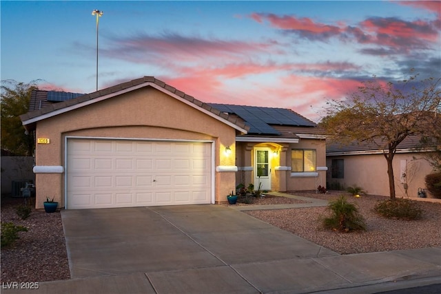 view of front of property with solar panels and a garage