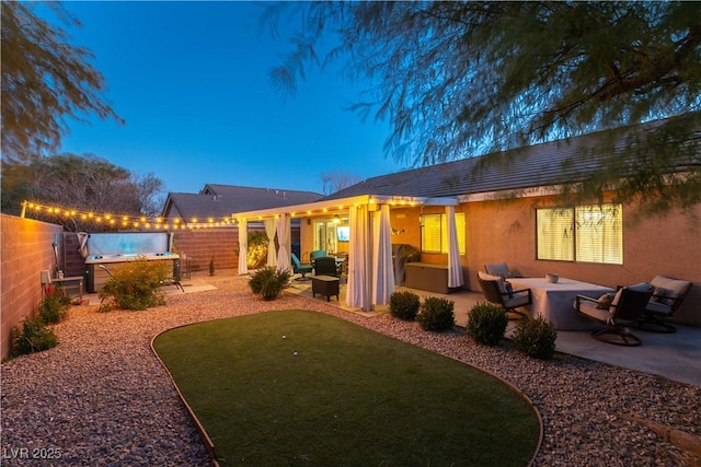 back house at dusk featuring a patio area