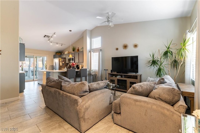 living room with ceiling fan, rail lighting, and lofted ceiling