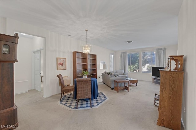 carpeted dining space featuring an inviting chandelier