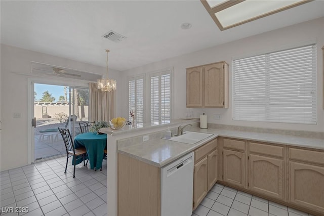 kitchen featuring kitchen peninsula, light brown cabinetry, sink, dishwasher, and hanging light fixtures