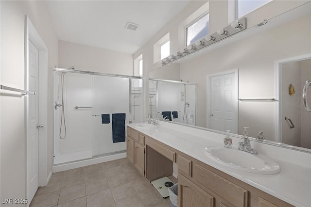 bathroom featuring tile patterned flooring, vanity, and walk in shower