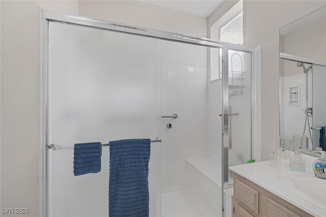 bathroom with vanity and a shower with door