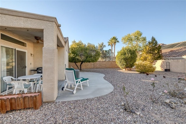 view of yard featuring ceiling fan and a patio