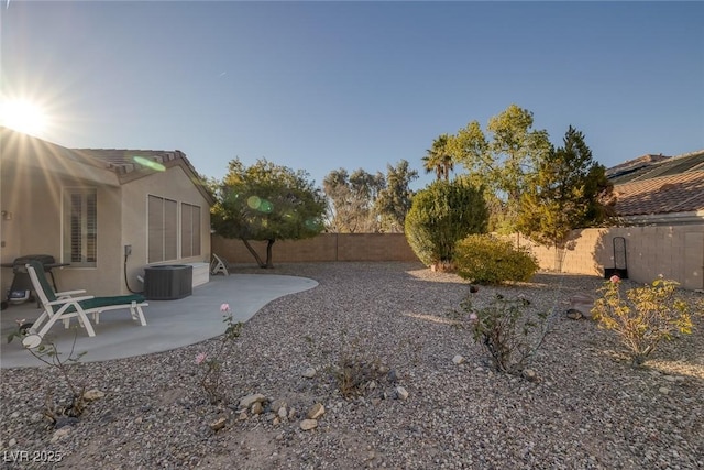 view of yard with central AC and a patio