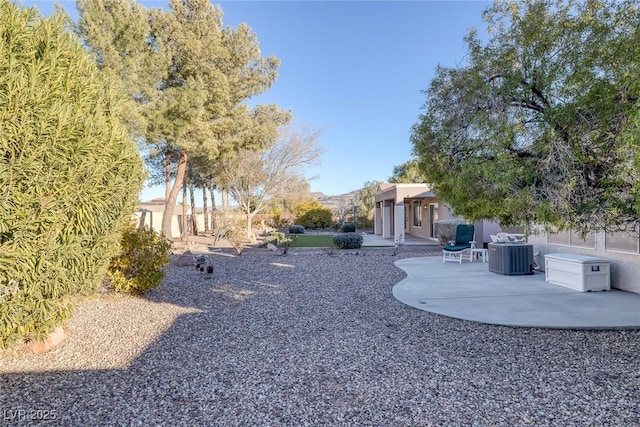 view of yard with a mountain view, central AC, and a patio area