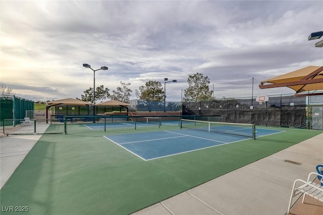 view of tennis court with basketball hoop