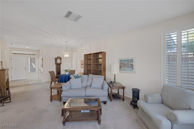 carpeted living room with a notable chandelier