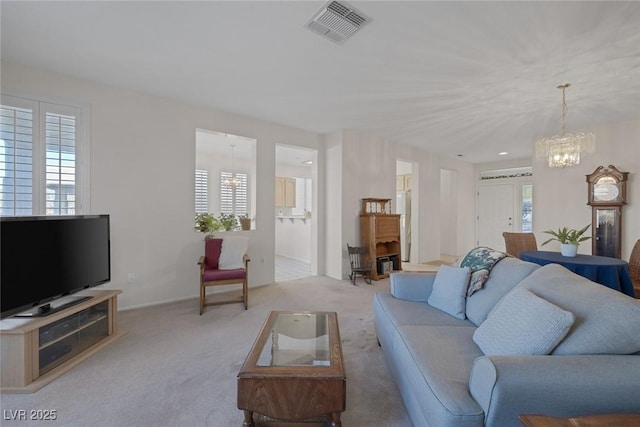 living room with a notable chandelier, light carpet, and a wealth of natural light