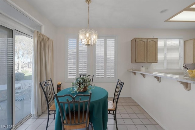 tiled dining space featuring a wealth of natural light and a notable chandelier