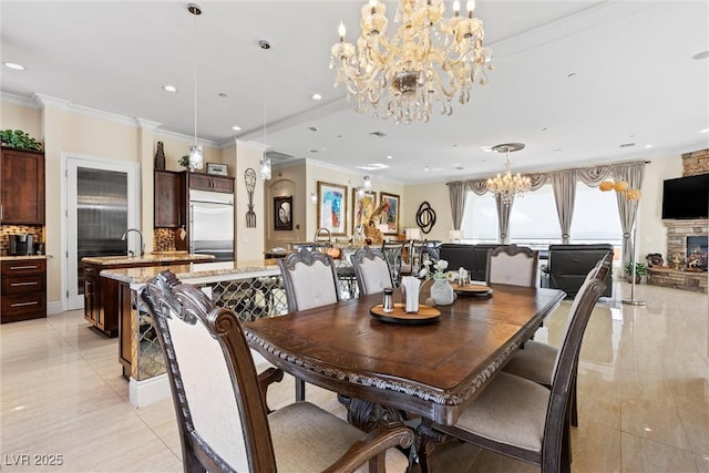 tiled dining space with a stone fireplace, sink, and ornamental molding