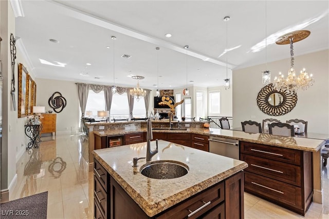 kitchen with pendant lighting, dishwasher, light stone countertops, and a large island with sink