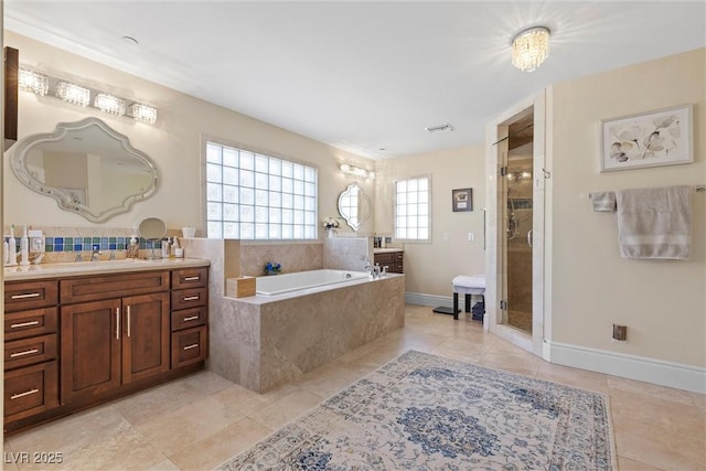 bathroom featuring tile patterned flooring, vanity, and separate shower and tub