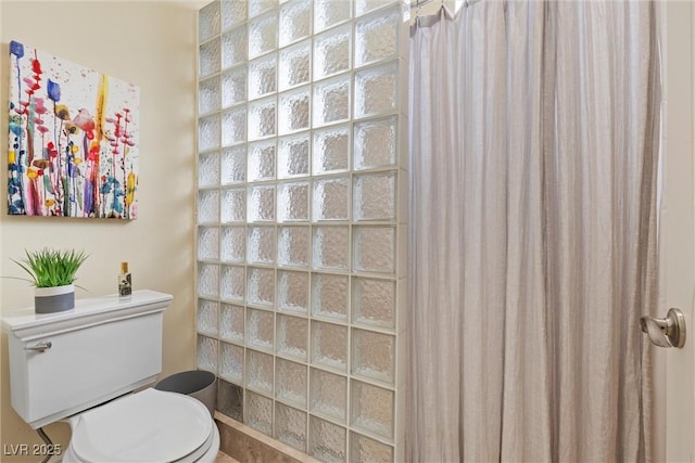 bathroom featuring toilet and a shower