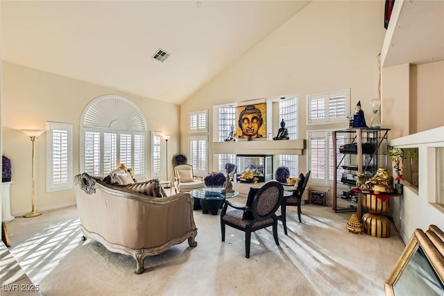 carpeted living room featuring a wealth of natural light and high vaulted ceiling