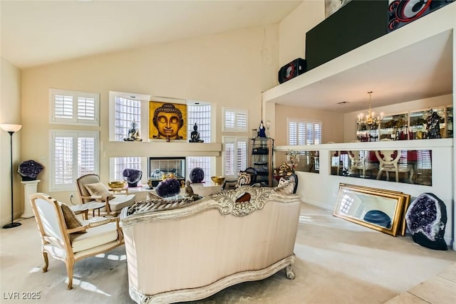 living room featuring a notable chandelier, a tile fireplace, and a towering ceiling