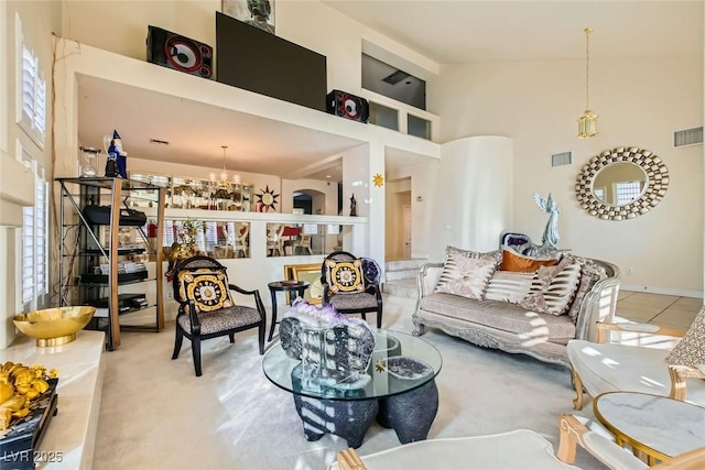 carpeted living room with a high ceiling and a chandelier