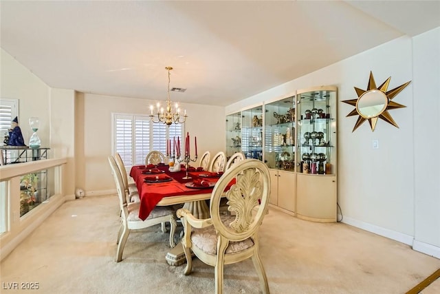 carpeted dining space featuring a chandelier