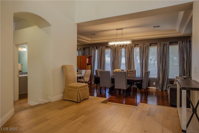 dining area with ornamental molding, a chandelier, and light wood-type flooring