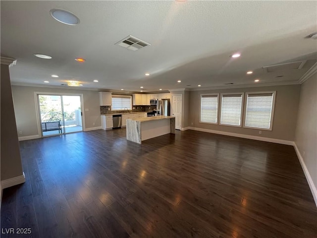 unfurnished living room with dark hardwood / wood-style floors, sink, and ornamental molding