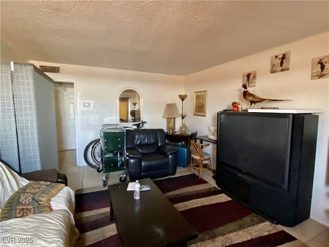 living room with a textured ceiling and tile patterned floors