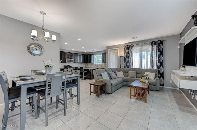 tiled living room with a notable chandelier