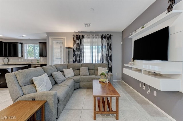 living room featuring sink and light tile patterned floors