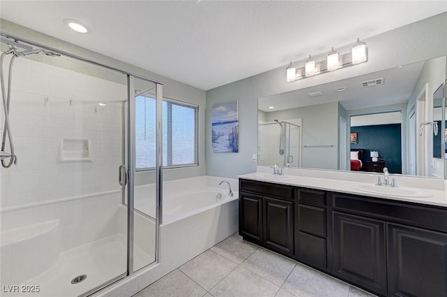 bathroom with tile patterned floors, vanity, and shower with separate bathtub