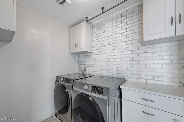 washroom with cabinets and washing machine and dryer