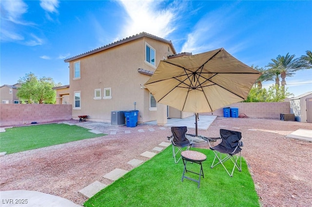 back of house featuring a yard, a storage unit, and central air condition unit