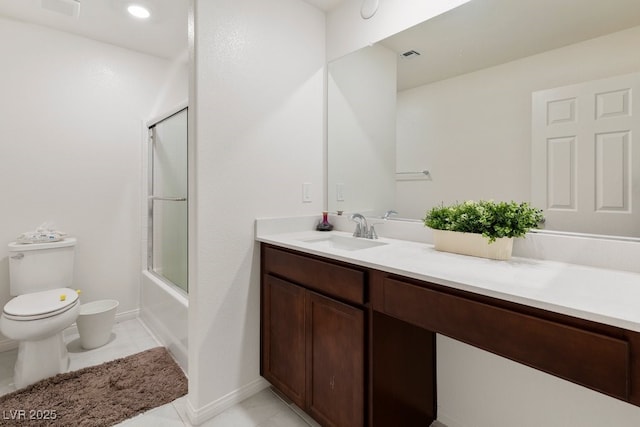 full bathroom with tile patterned floors, vanity, toilet, and bath / shower combo with glass door