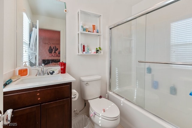 full bathroom with vanity, bath / shower combo with glass door, and toilet