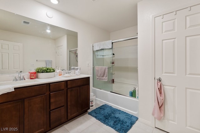 bathroom featuring tile patterned flooring, vanity, and enclosed tub / shower combo