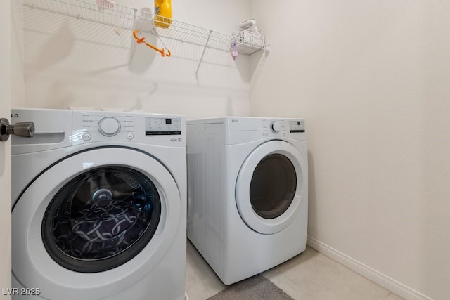 laundry room with washing machine and dryer and light tile patterned flooring